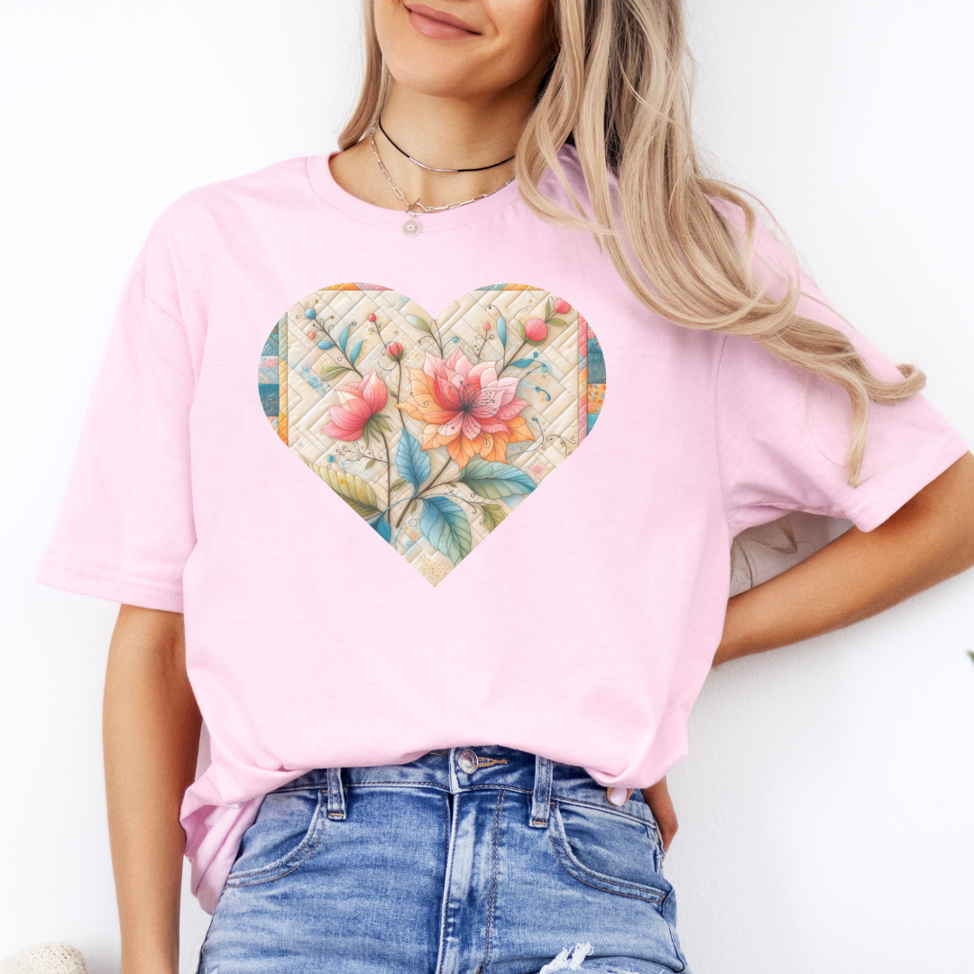 a woman wearing a pink t - shirt with a floral heart on it