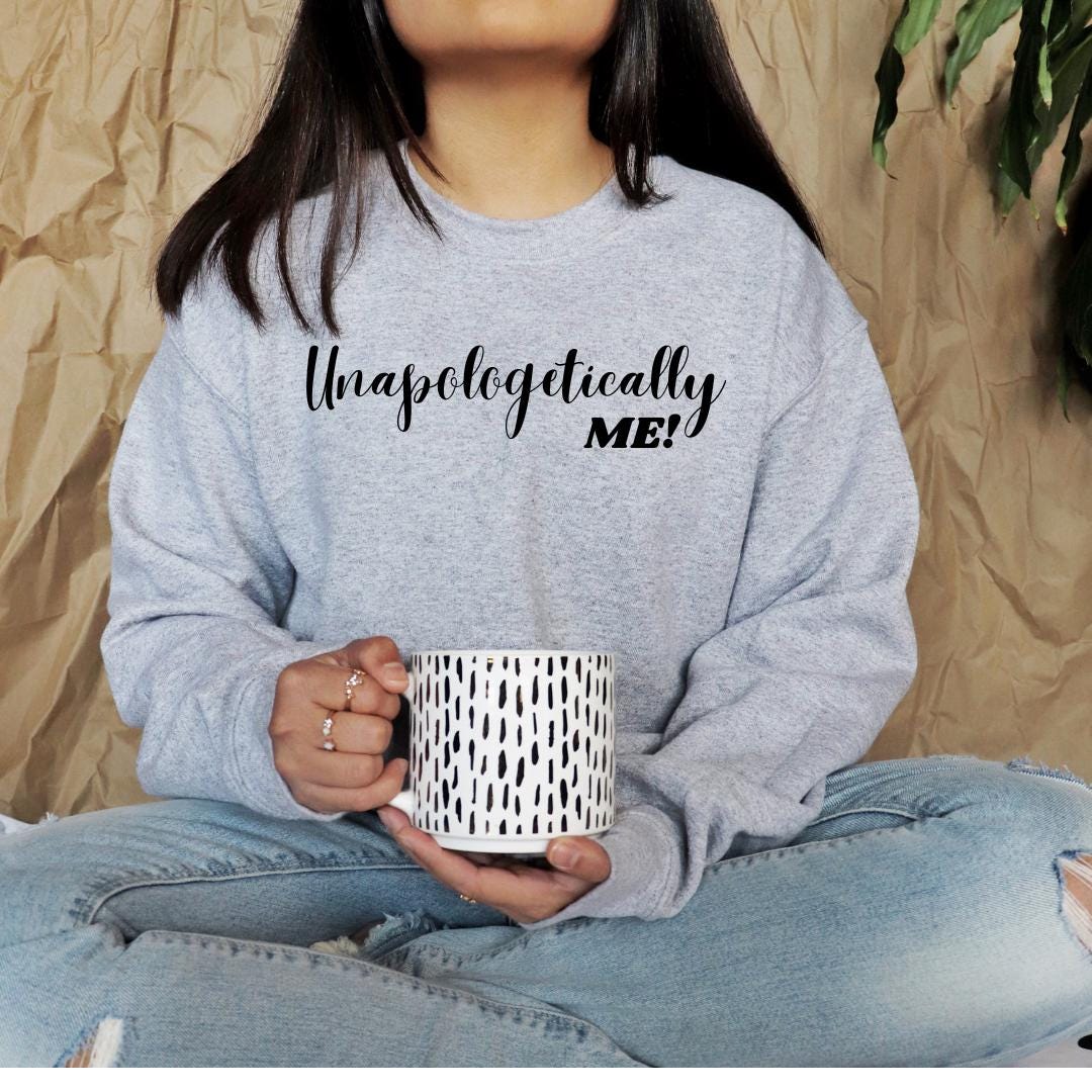 a woman sitting on the floor holding a coffee cup