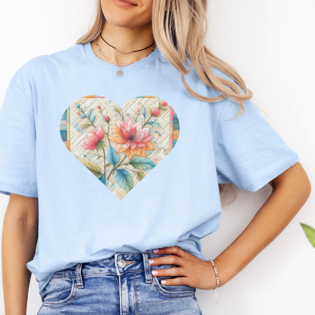 a woman wearing a blue t - shirt with a floral heart on it