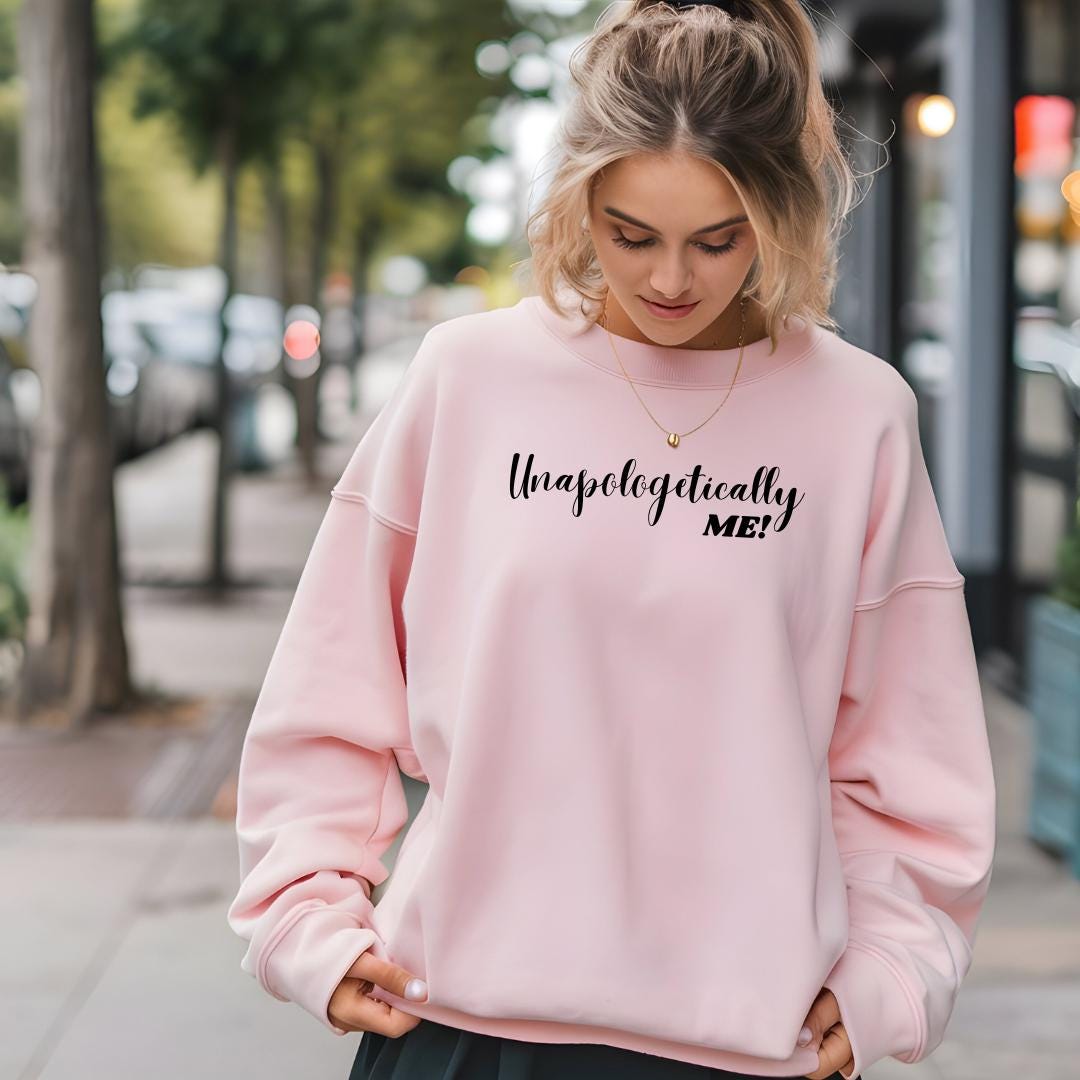 a woman wearing a pink sweatshirt and black pants